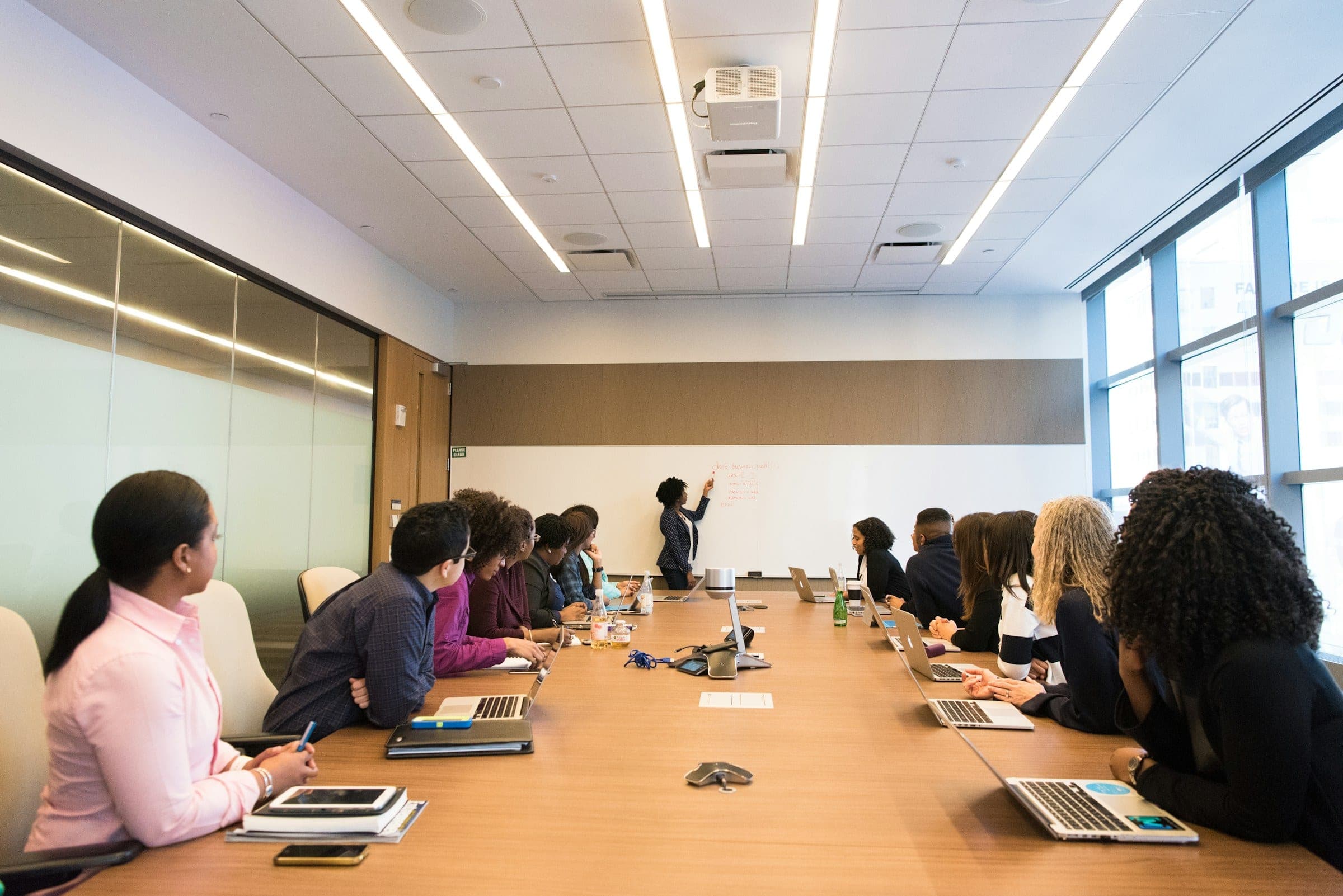 A training session in progress around a long table, one participant presenting.