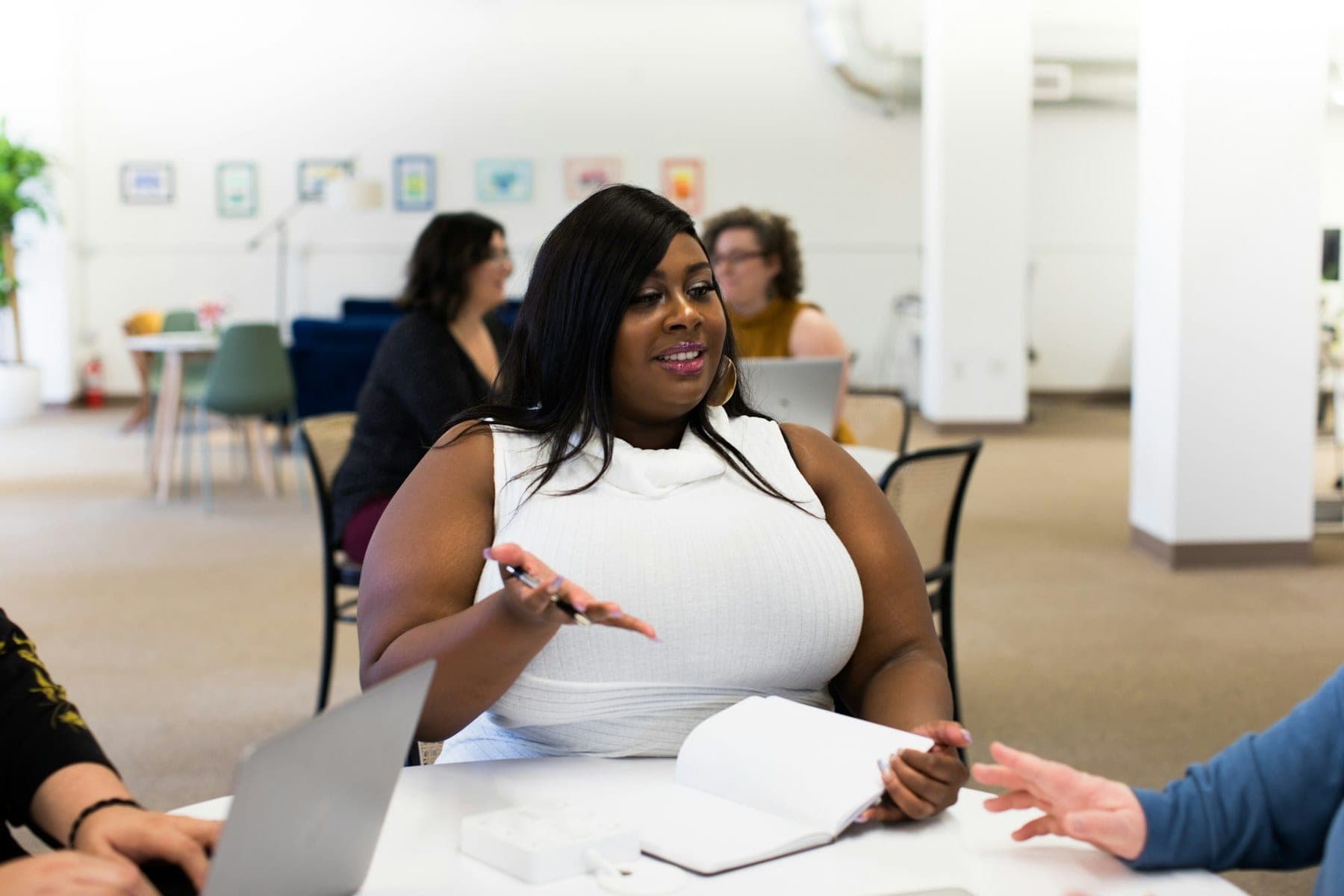 A woman making a point across a table during a business discussion.